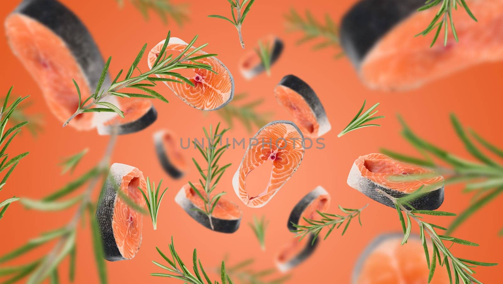 Raw salmon steaks and rosemary sprigs levitate on an orange background