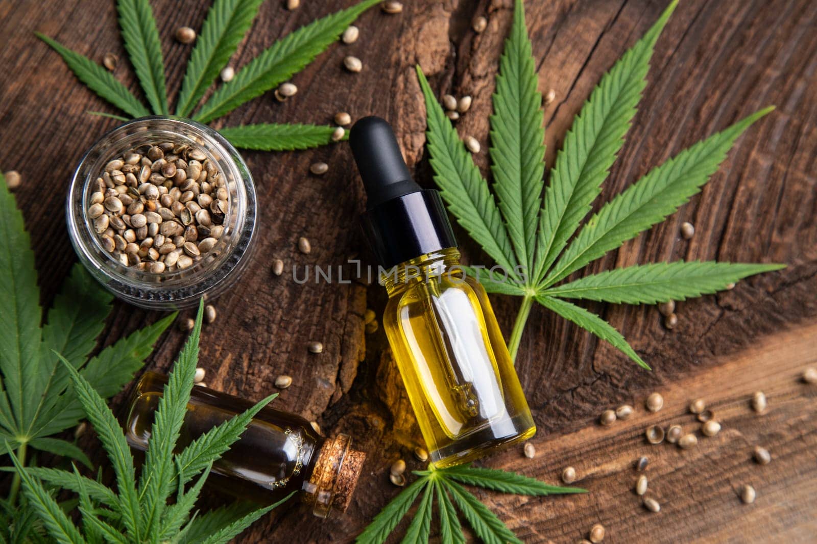 Cannabis oil bottle and marijuana leaves