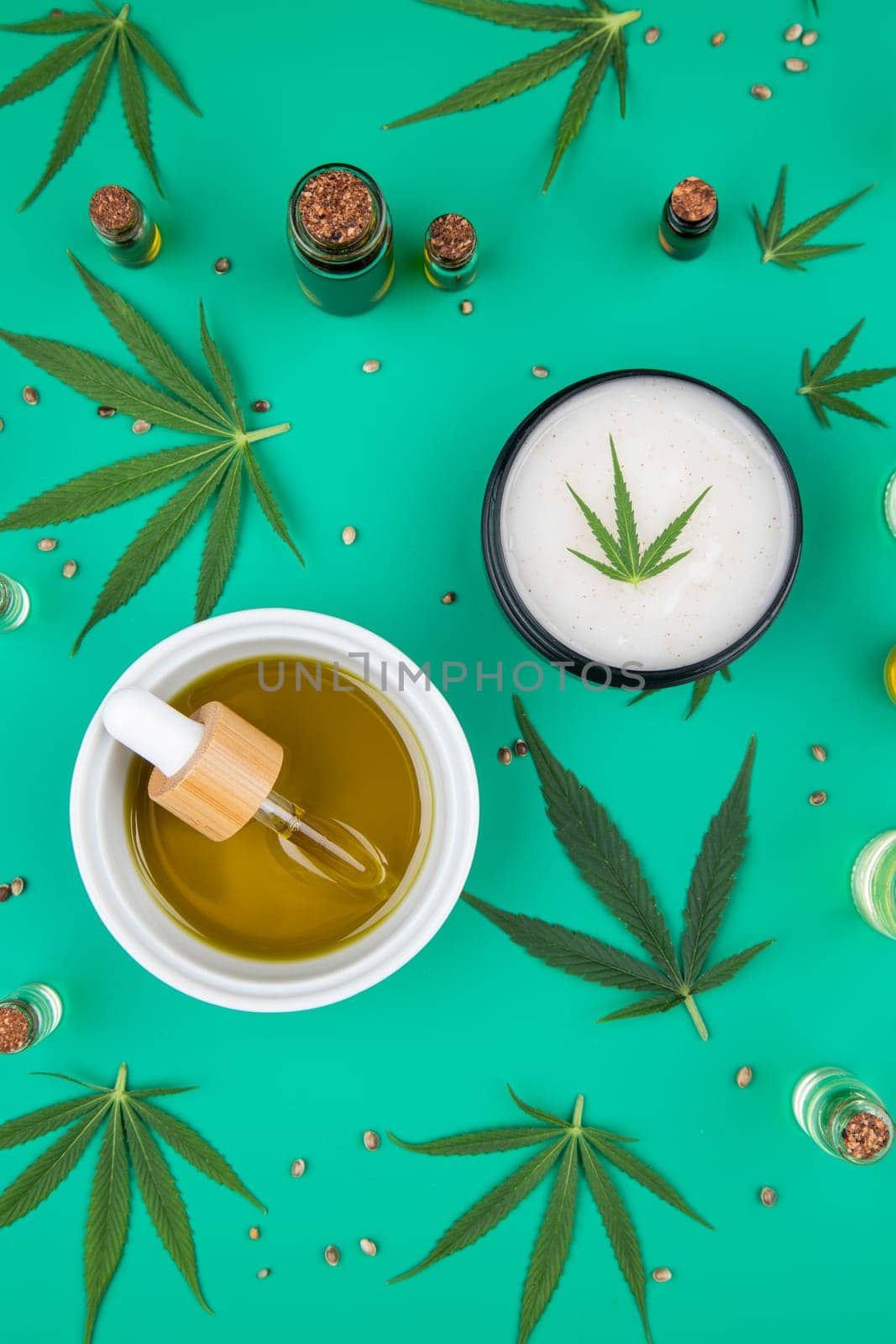 Flat lay composition of marijuana and hemp seeds on color green background