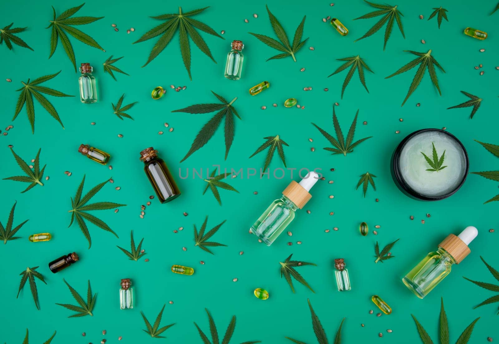 Flat lay composition of marijuana and hemp seeds on color green background