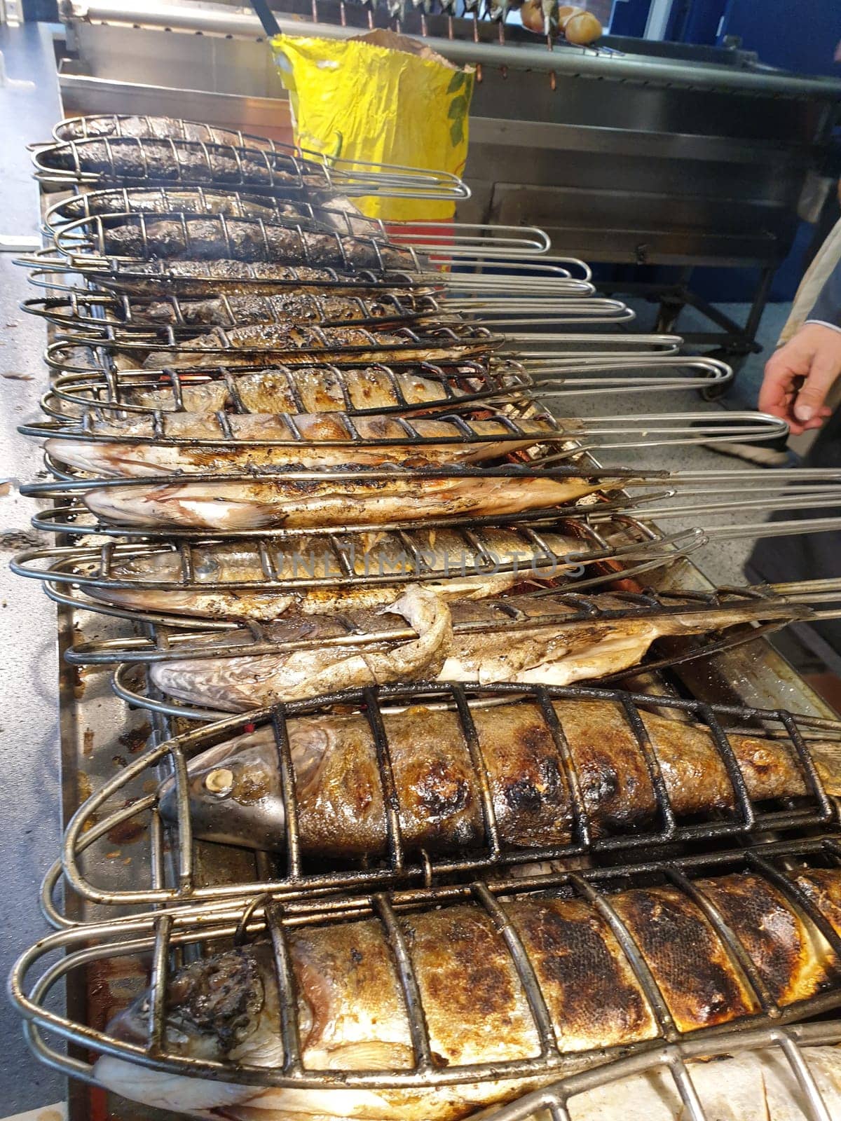 A fresh fish is grilled on a gas grill and sold at the market. Herring,trout,char,salted herring and mackerel. Tools are fish roaster,fish holder,fish grill and grill basket.