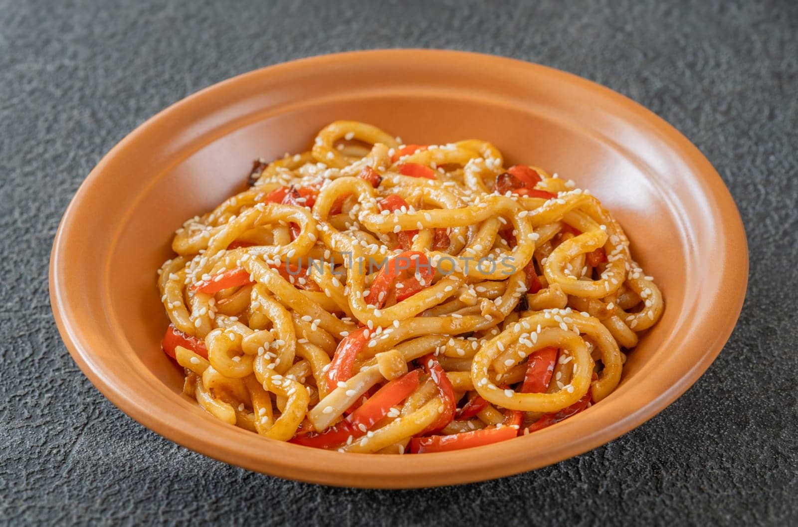 Bowl of udon noodles with bell pepper and mushrooms