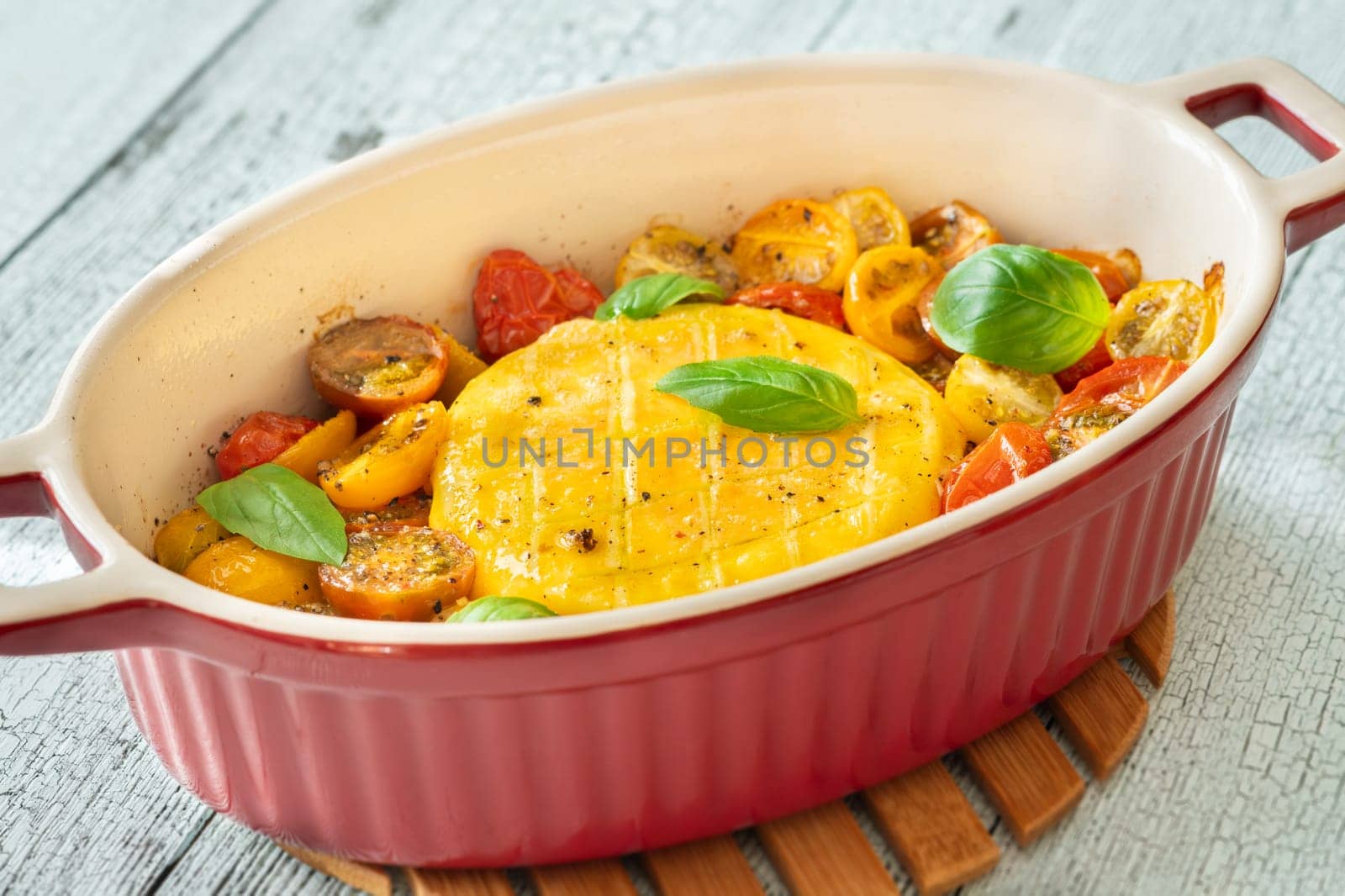 Baked camembert cheese with cherry tomatoes and basil