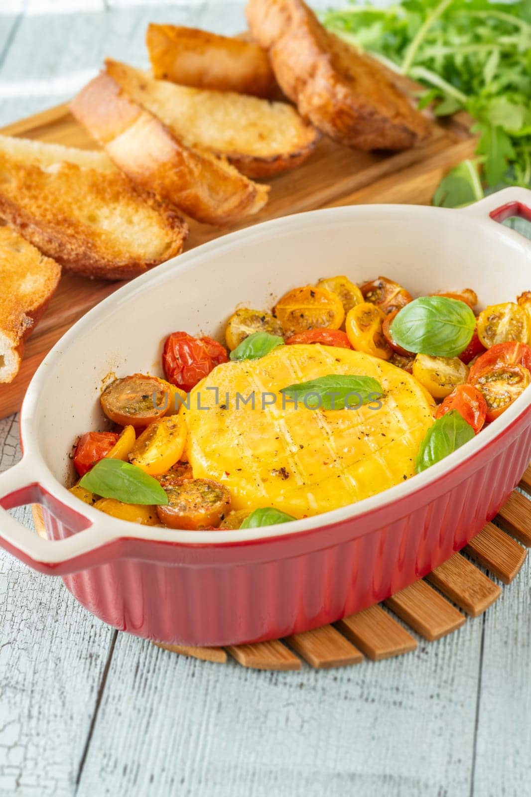 Baked camembert cheese with cherry tomatoes and basil