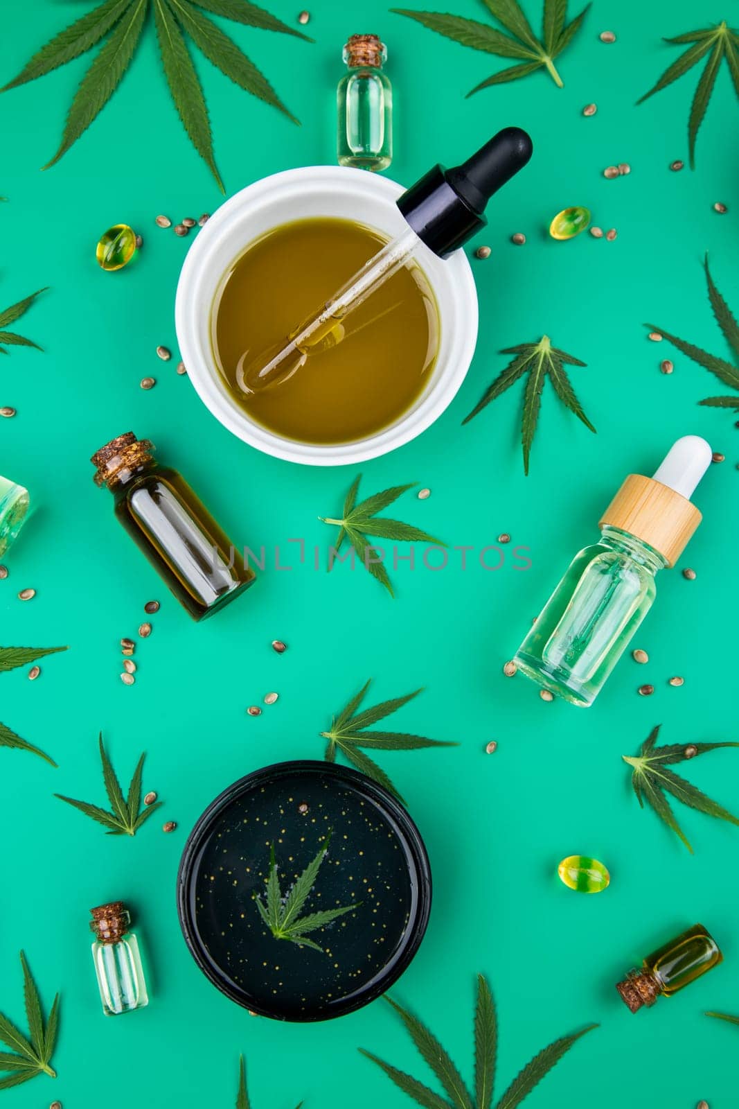Flat lay composition of marijuana and hemp seeds on color green background