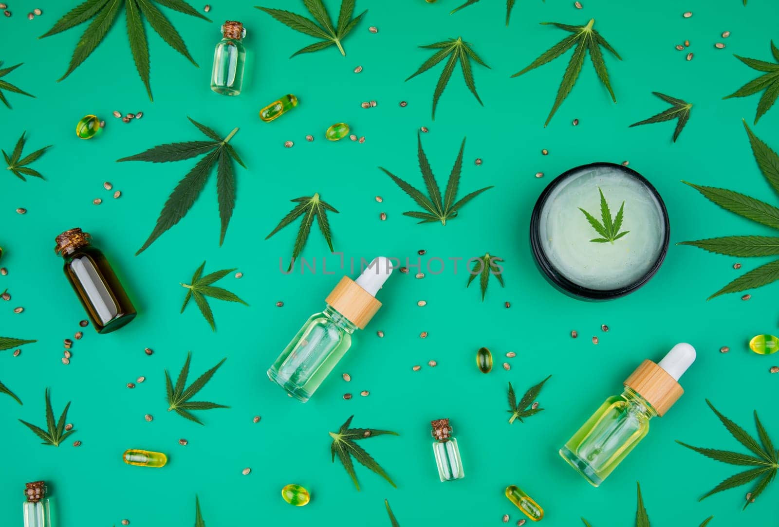 Flat lay composition of marijuana and hemp seeds on color green background
