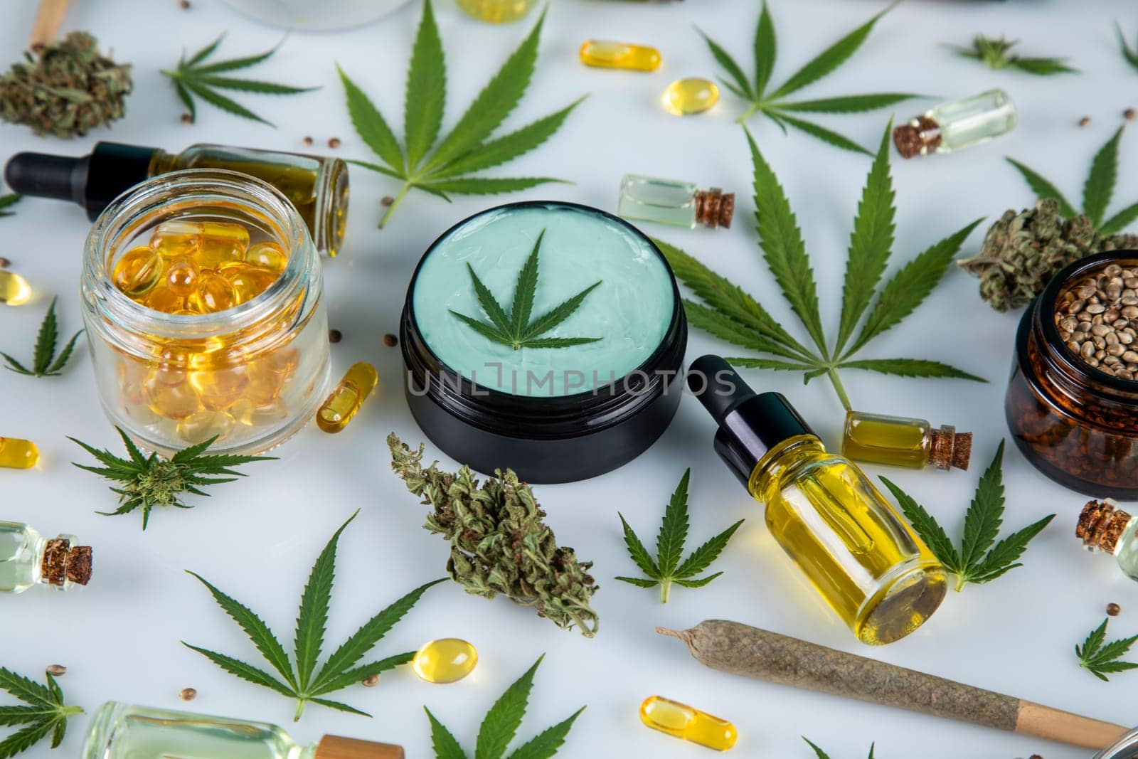 Top view of marijuana leaves and cannabis buds on white background