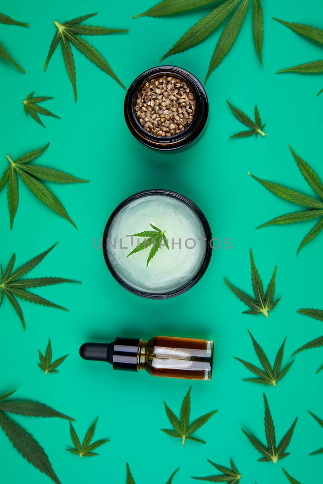 Flat lay composition of marijuana and hemp seeds on color green background
