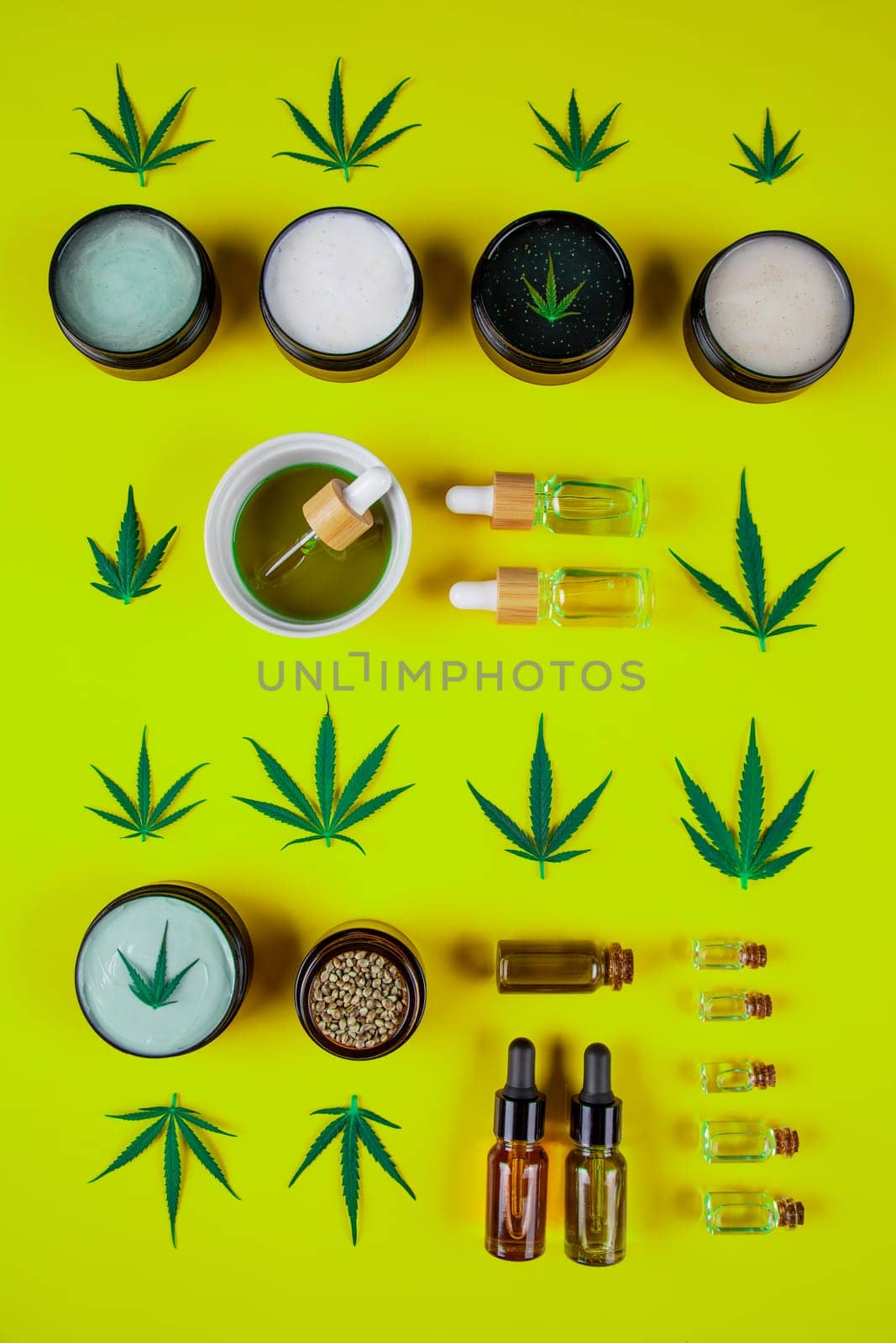 Set of cannabis oil bottles with hemp oil on yellow background. top view. flat lay