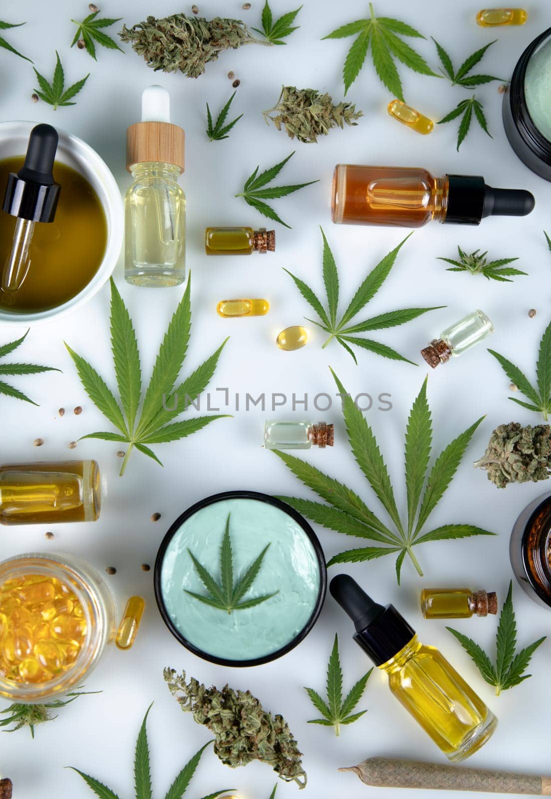 Flat lay composition with marijuana leaves, bottle of oil, cannabis on cbd, white background