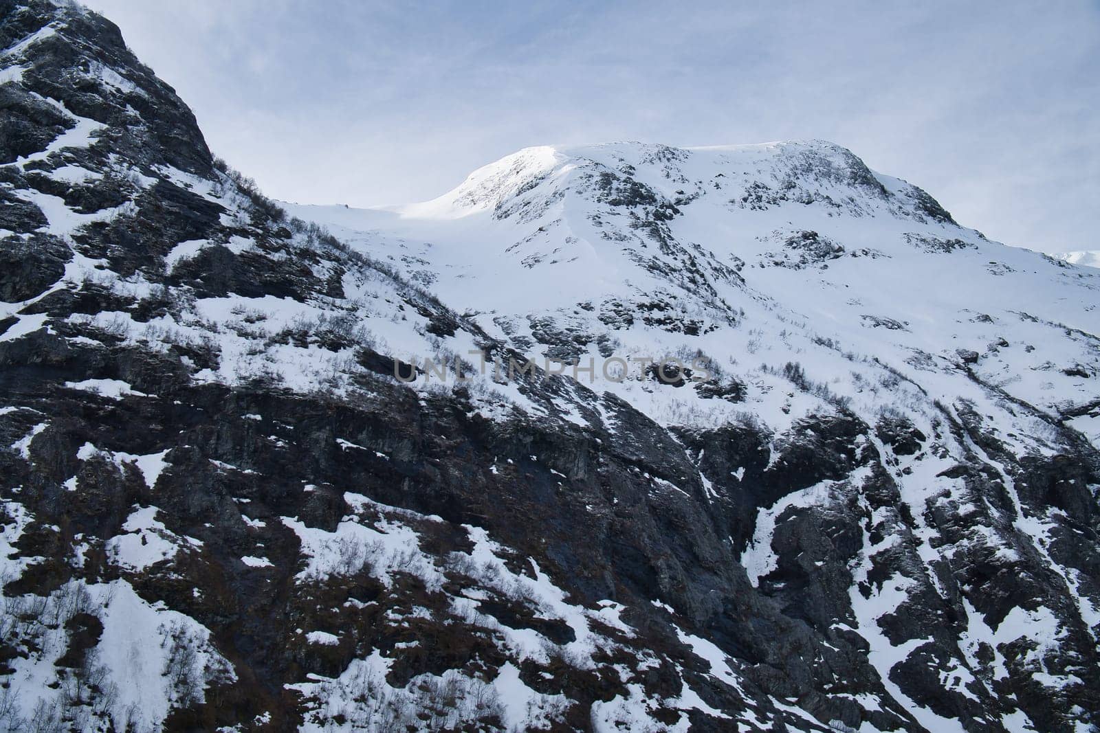 Norwegian landscape. The road leads through a mountain gorge that descends from the glacier. Rough nature in Scandinavia. Landscape photo from the north