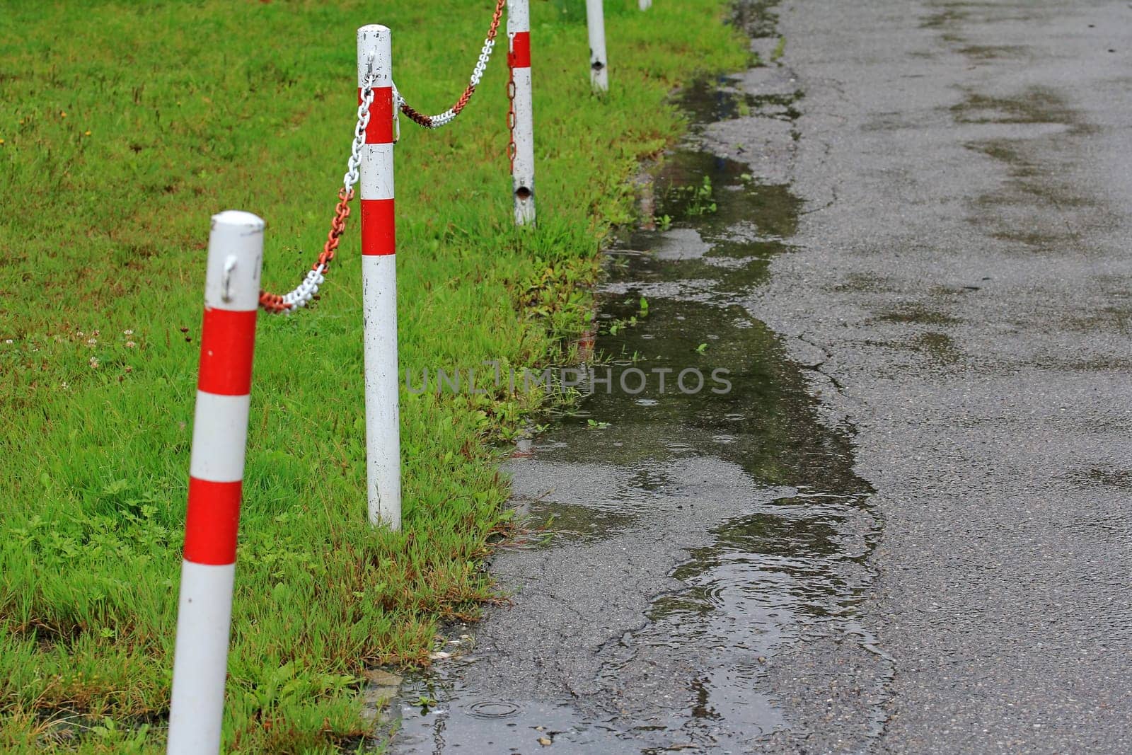 Eine regennasse Straße mit einer Absperrung