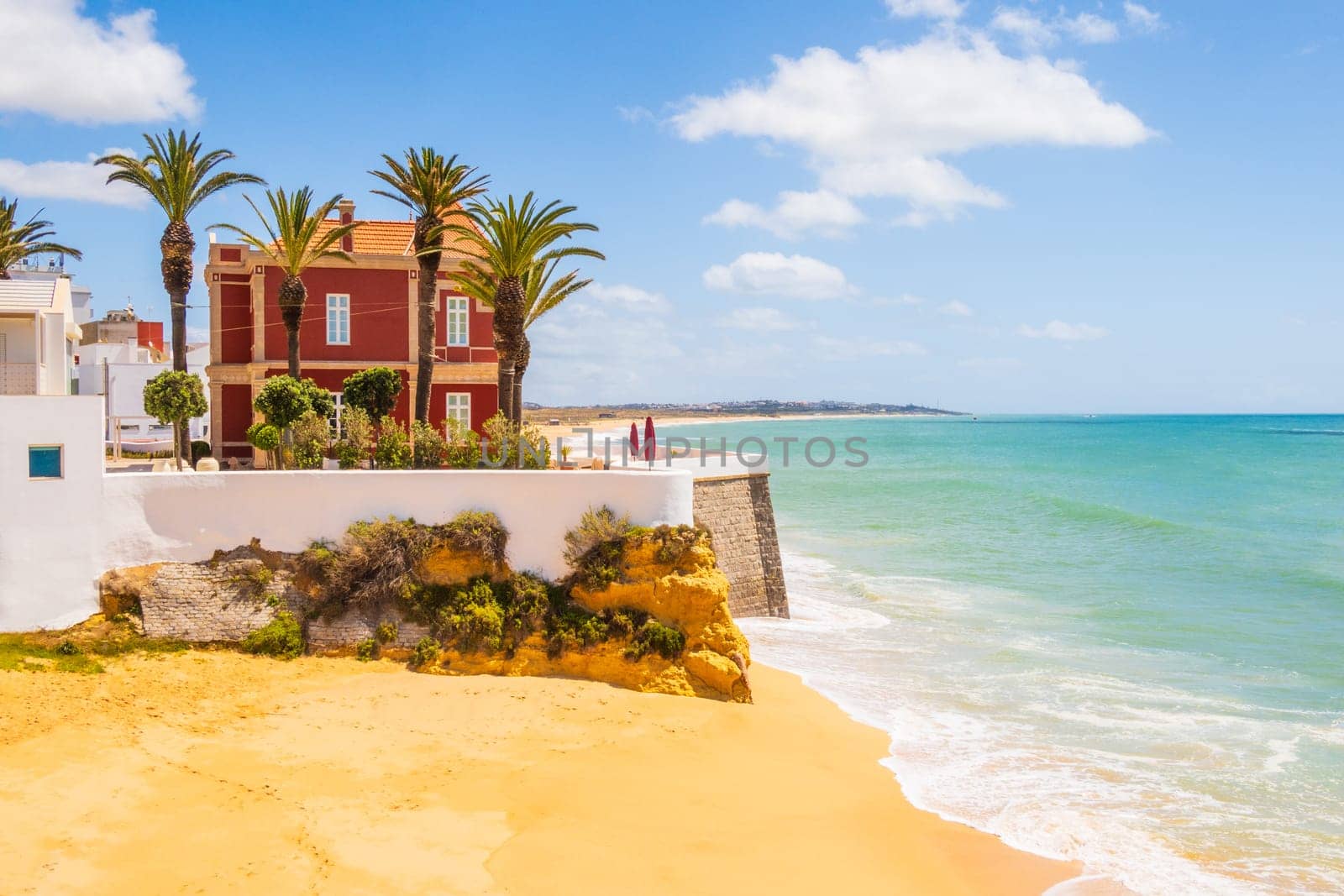 View of palm trees and beach in Armação de Pêra, Algarve, Portugal