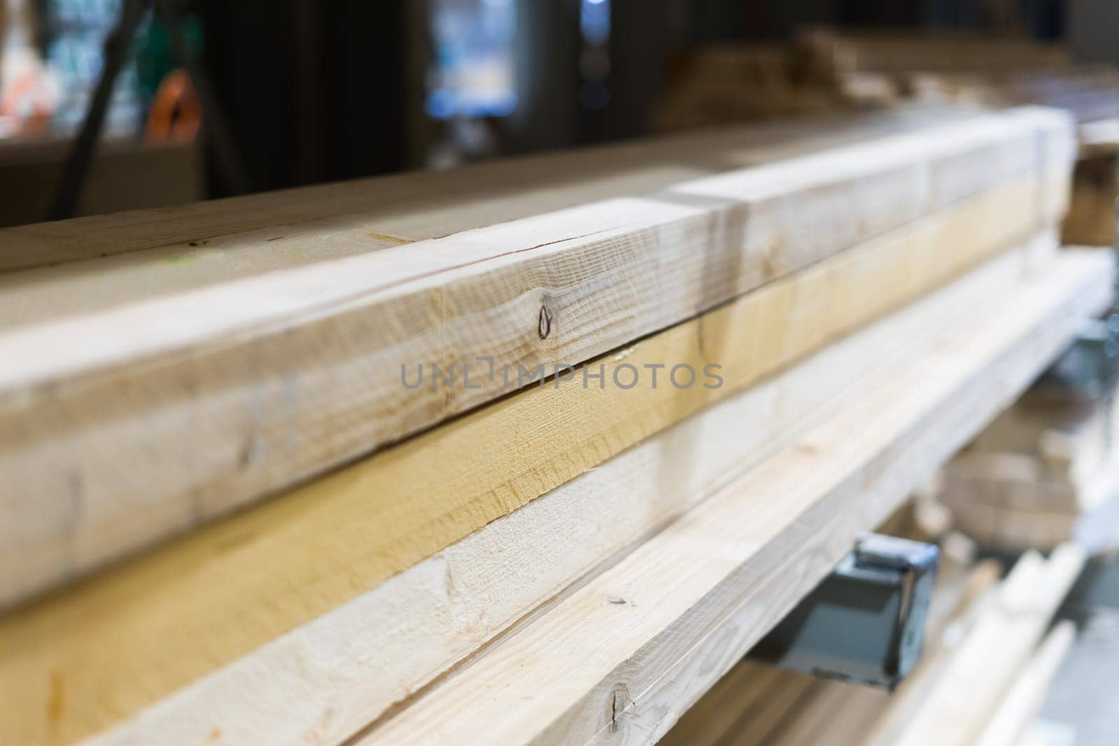 Pile of long square section wooden sticks, slightly bent. Closeup with selective focus.