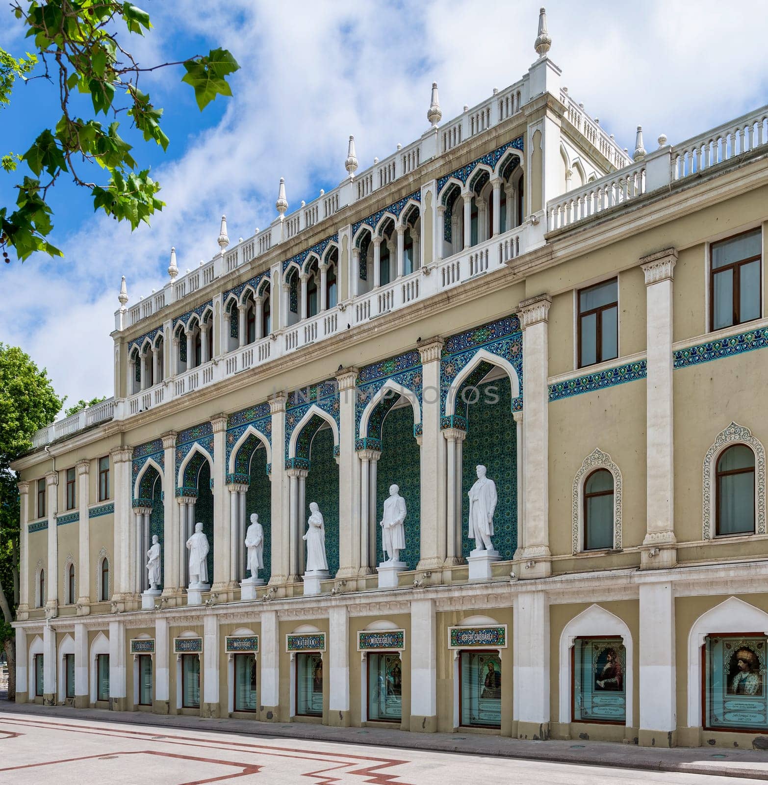 Nizami Museum of Azerbaijan, with statues lining the facade. The building is decorated with arches and intricate tile work, located in Baku near the famous Nizami Street