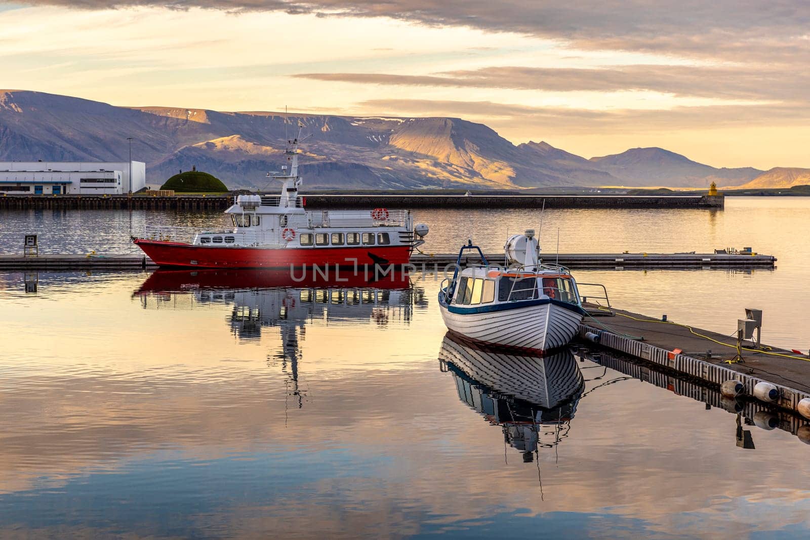 Two boats reflecting  water reykjavik harbor sunset  mountains background