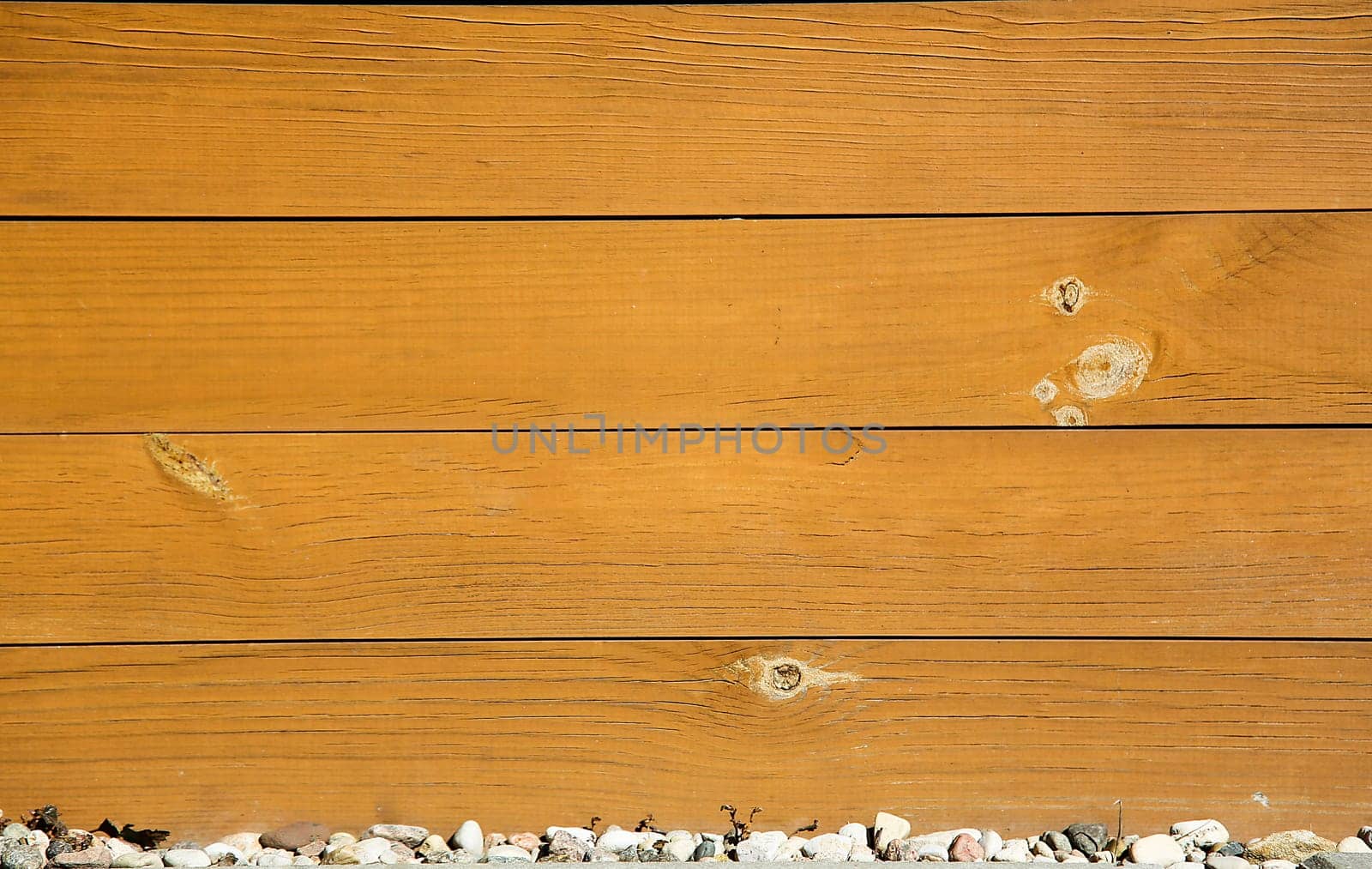 Close-up of horizontal wooden planks with rustic texture above a row of small stones, background image