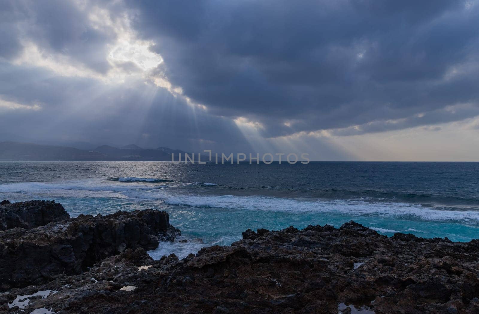 Beautiful sunrays on the Atlantic coast in Las Palmas de Gran Canaria, view from Las Canteras beach