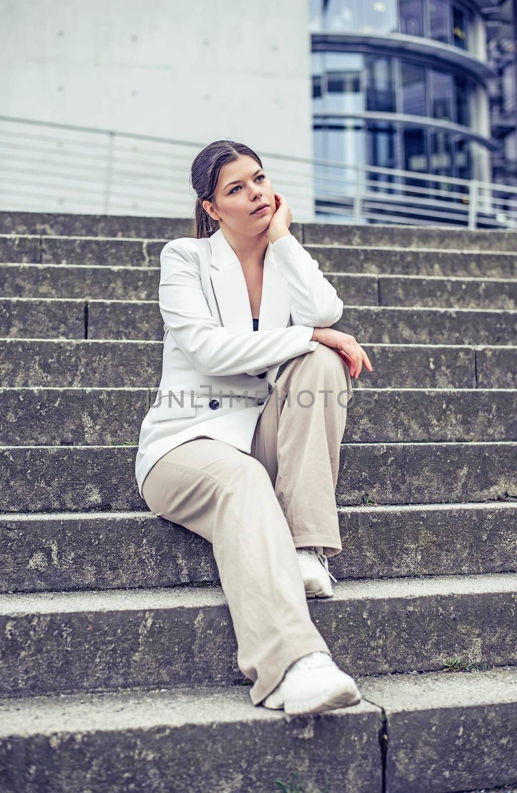 pensive young woman sitting on a staircase