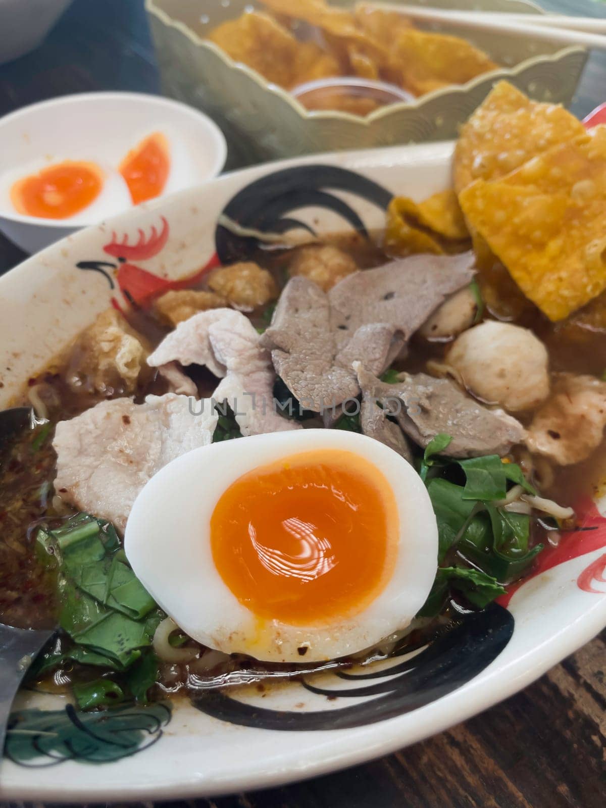 Hot and spicy Thai noodle soup with soft boiled egg, stock photo