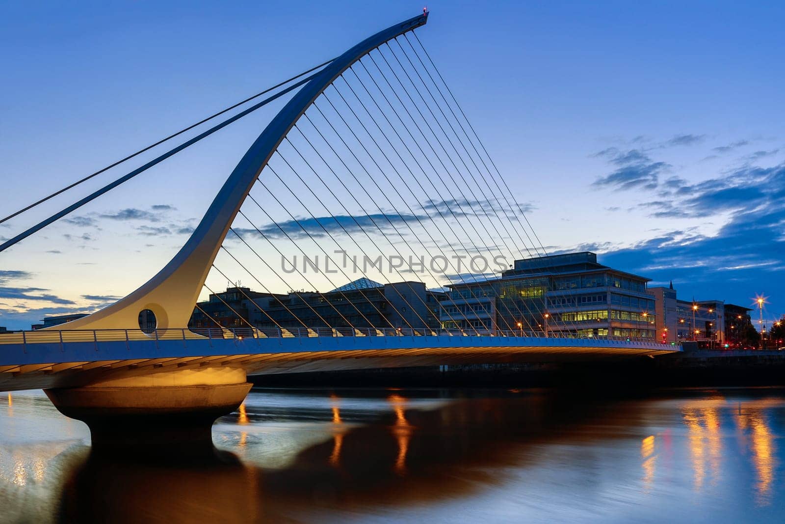 The Samuel Beckett Bridge and the building on the waterfront near the Convention Center - Dublin city center in the republic of Ireland. This is a cable-stayed bridge that joins Sir John Rogerson's Quay on the south side of the River Liffey to Guild Street and North Wall Quay in the Docklands area. The innovative architect Santiago Calatrava designed this and a number of other bridges and buildings in Ireland.