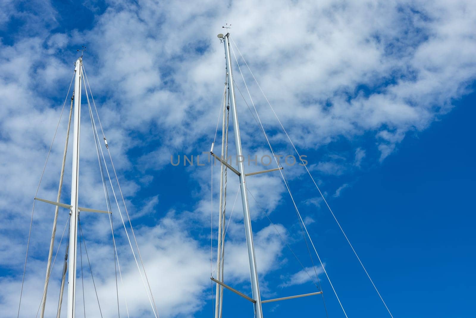 The tops of the yacht's masts against the bright sky.