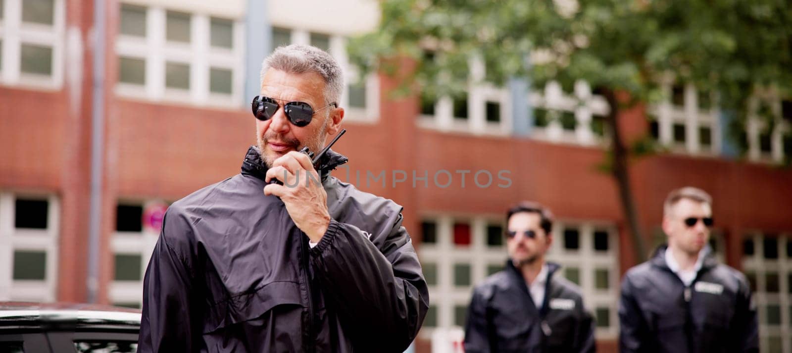 VIP Security Officer Safeguarding Luxury Car Business Client Outside Corporate Event with Walkie-Talkie Protection Services for High-End Executives.