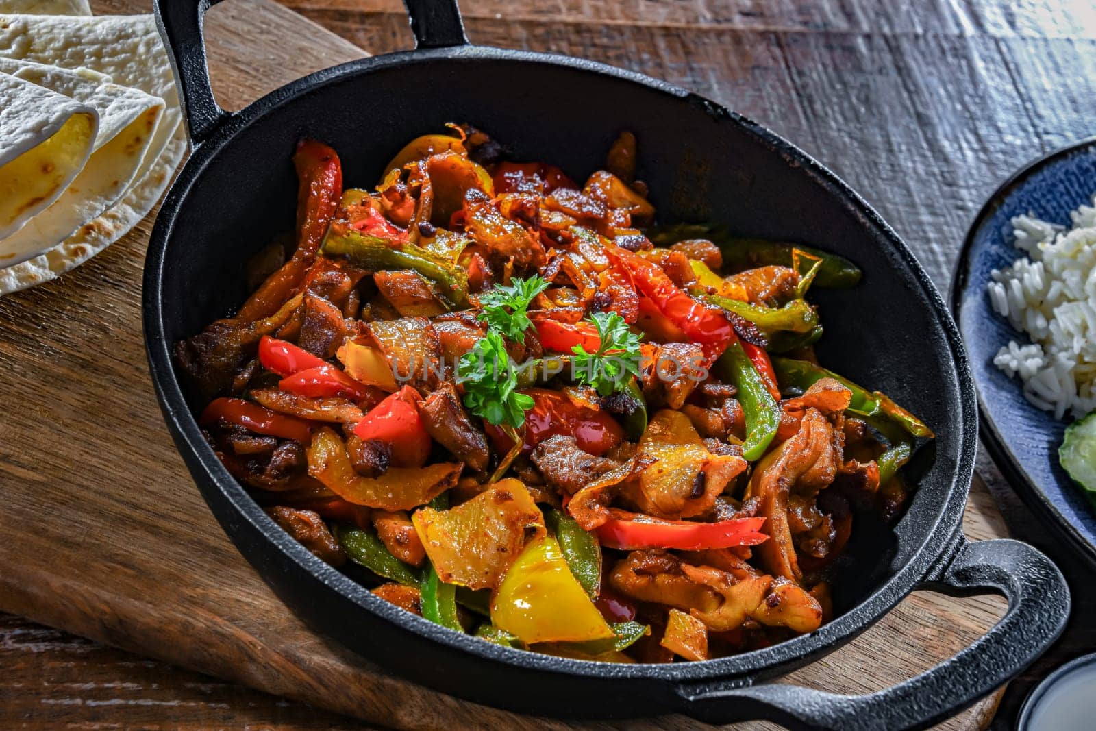 Fajita with stripped peppers and onions served on a hot iron skillet