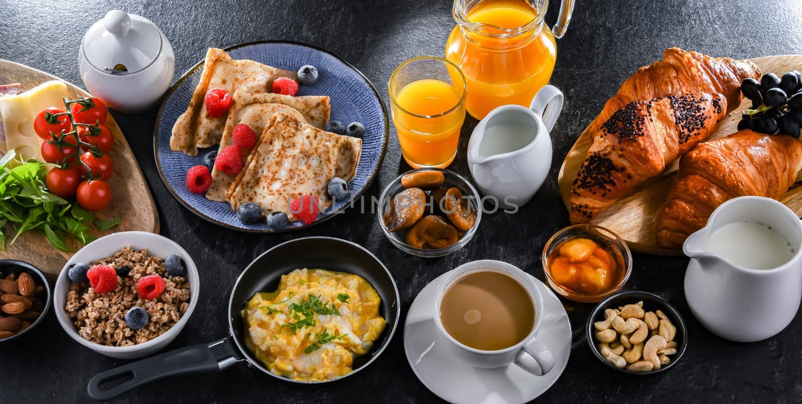 Breakfast served with coffee, orange juice, scrambled eggs, cereals, pancakes and croissants.