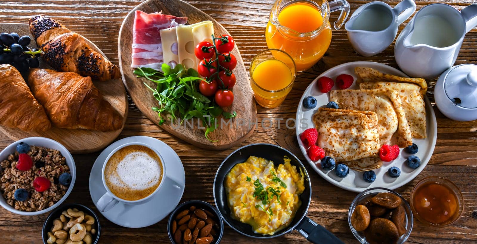 Breakfast served with coffee, orange juice, scrambled eggs, cereals, pancakes and croissants.