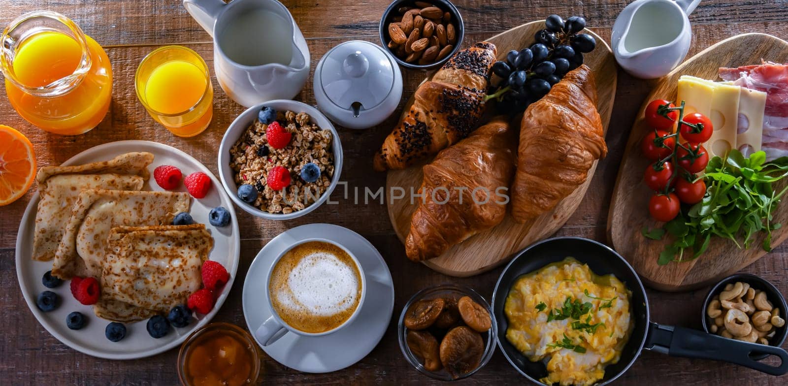 Breakfast served with coffee, orange juice, scrambled eggs, cereals, pancakes and croissants.