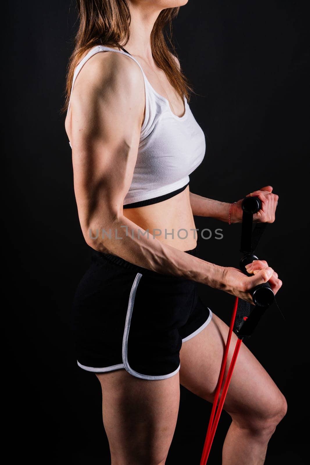 Athletic female performs exercises using resistance band. Strength and motivation