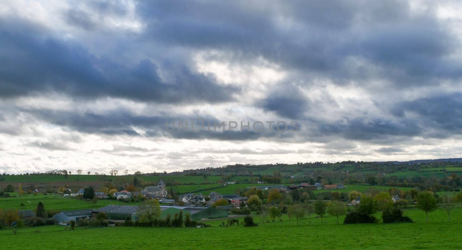 a landscape of normandy countryside, cloudy sky