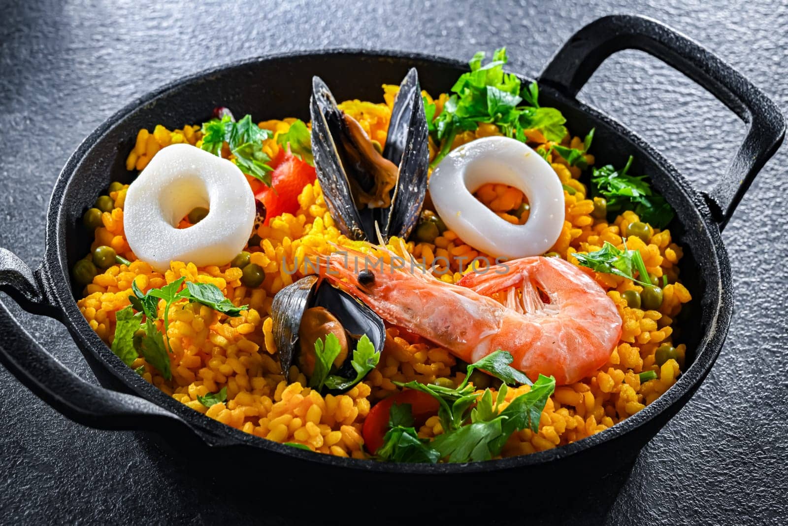 Seafood paella served in a cast iron pan.