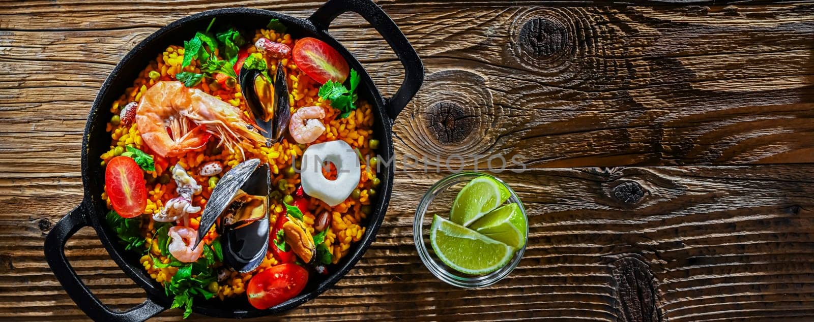 Seafood paella served in a cast iron pan.