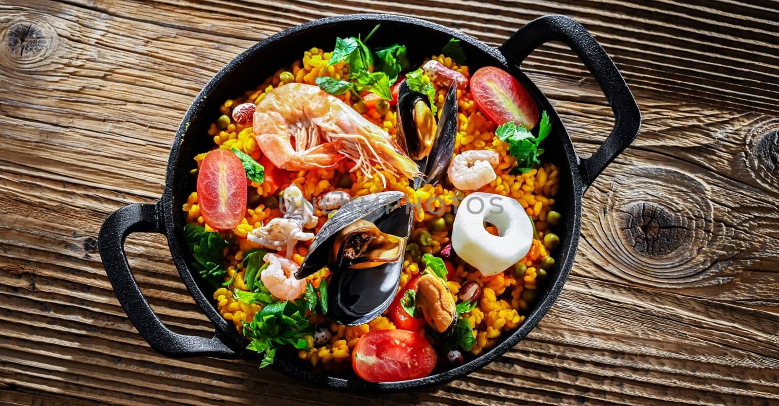 Seafood paella served in a cast iron pan.