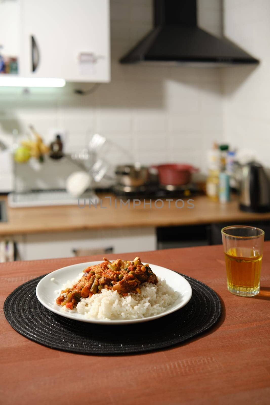 Homemade spicy chicken stew with vegetables and rice on a kitchen table