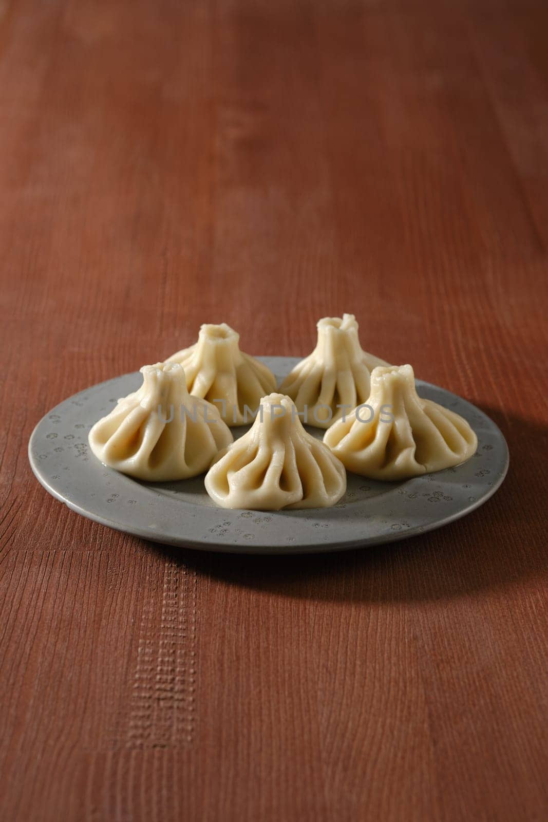 Georgian boiled dumplings - khinkali stuffed with lamb or beef minced meat on a plate