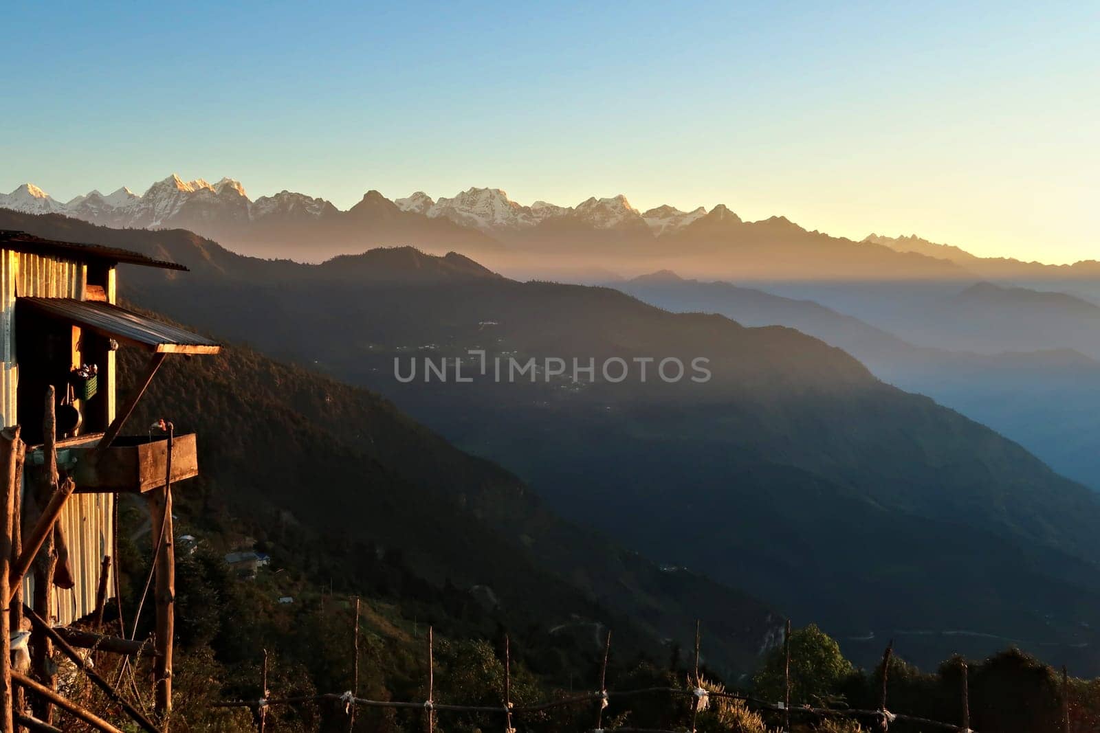 Wooden farmers house in front of the Himalaya Mountain Range in the distance at golden hour, seen on the off-road ride from kathmandu to Salleri, Phaplu, Bupsa, Jubing, Nepal 2022