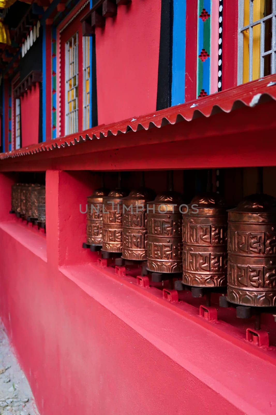 The copper prayer wheels on the colorful facade of the monastery in Monjo, Manjo village, Mount Everest Basecamp Trek, EBC, Nepal 2022