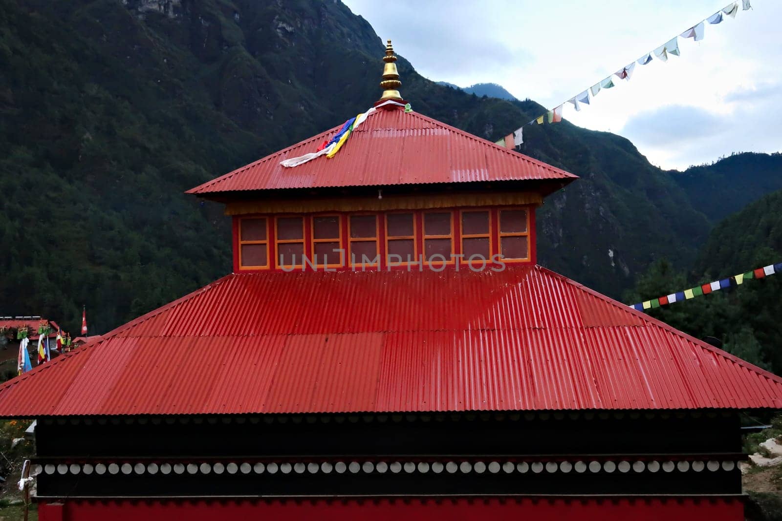 The red roof of the monastery built on a hill in the Monjo, Manjo village on the Mount Everest Basecamp Trek, EBC, Nepal 2022