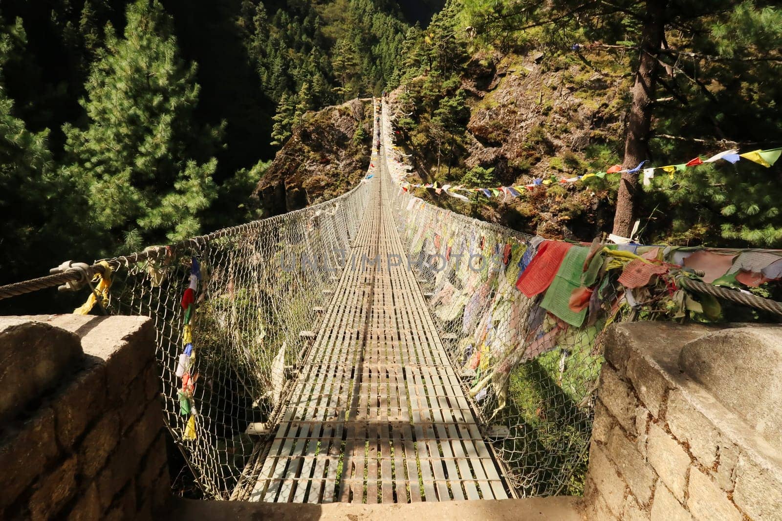The famous Hillary bridge, a long metal suspension bridge between Phakding and Namche Bazar, Bazaar, covered in many colorful prayer flags, Mount Everest Basecamp Trek, EBC, Nepal 2022