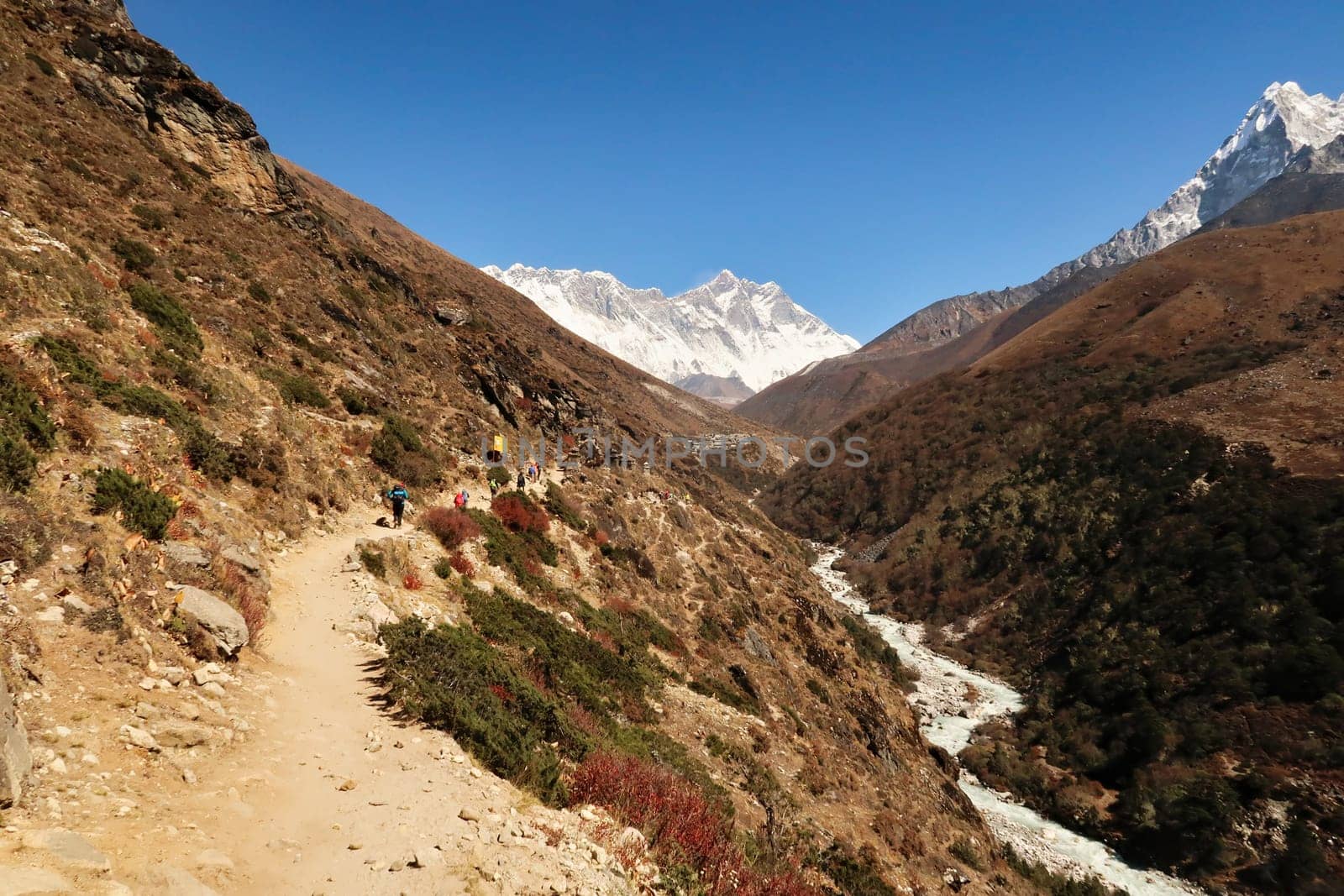 On the trail along the Imja Khola River, a part of Mount Ama Dablam can be seen on the right, the village of Shomare in front of Mount Nuptse, Everest and Lhotse in the background, Mount Everest Base Camp Trek, EBC, Nepal 2022