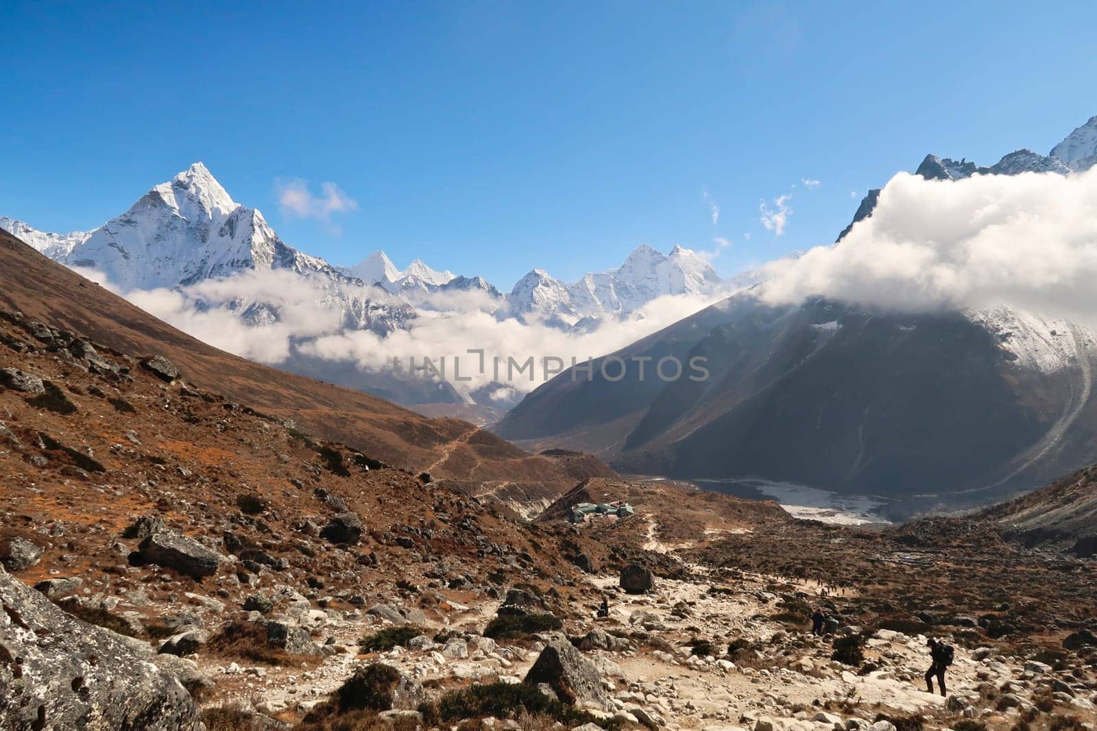 Walking up towards the Everest Memorial Chukpi Lhara, the Dughla, Thukla village in the foreground, Mount Amphu Gyabjen, Ama Dablam, Kangtega and Thamserku in the background, Mount Everest Base Camp Trek, EBC, Nepal 2022