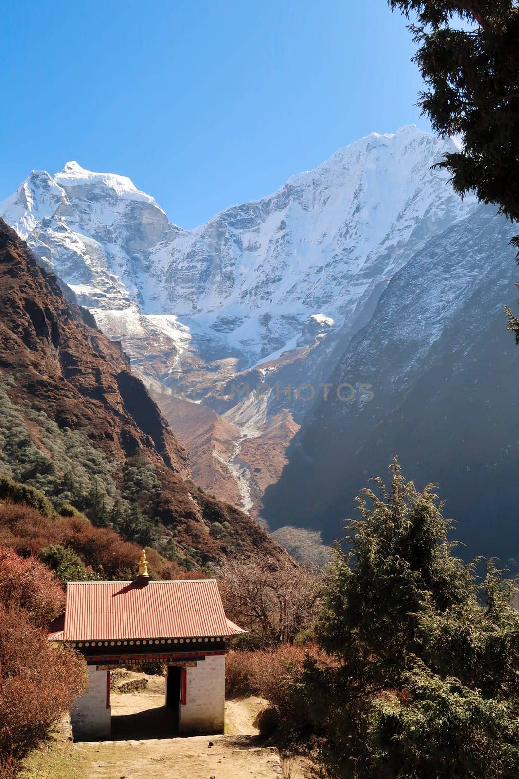 Tibetan buddhist gate on the trail on the way out of Tengboche, Tangboche towards Namche Bazaar, Bazar, Mount Kangtega can in the background, Mount Everest Base Camp Trek, EBC, Nepal 2022