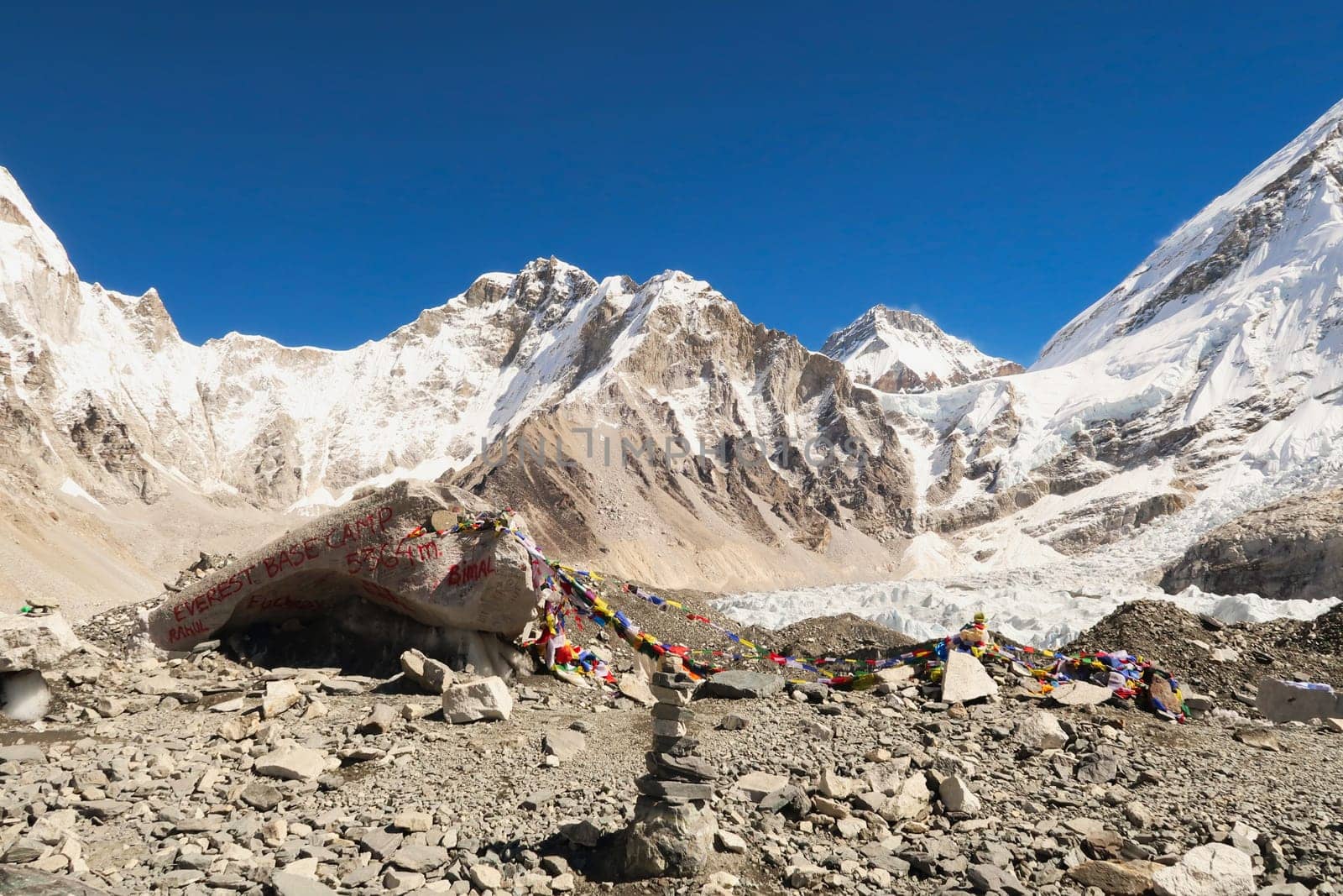At the Base Camp of Mount Everest, a large rock, boulder, sprayed with red graffiti, paint marks the site, Mount Khumbutse and Changtse are visible in the background, Mount Everest Base Camp Trek, EBC, Nepal 2022