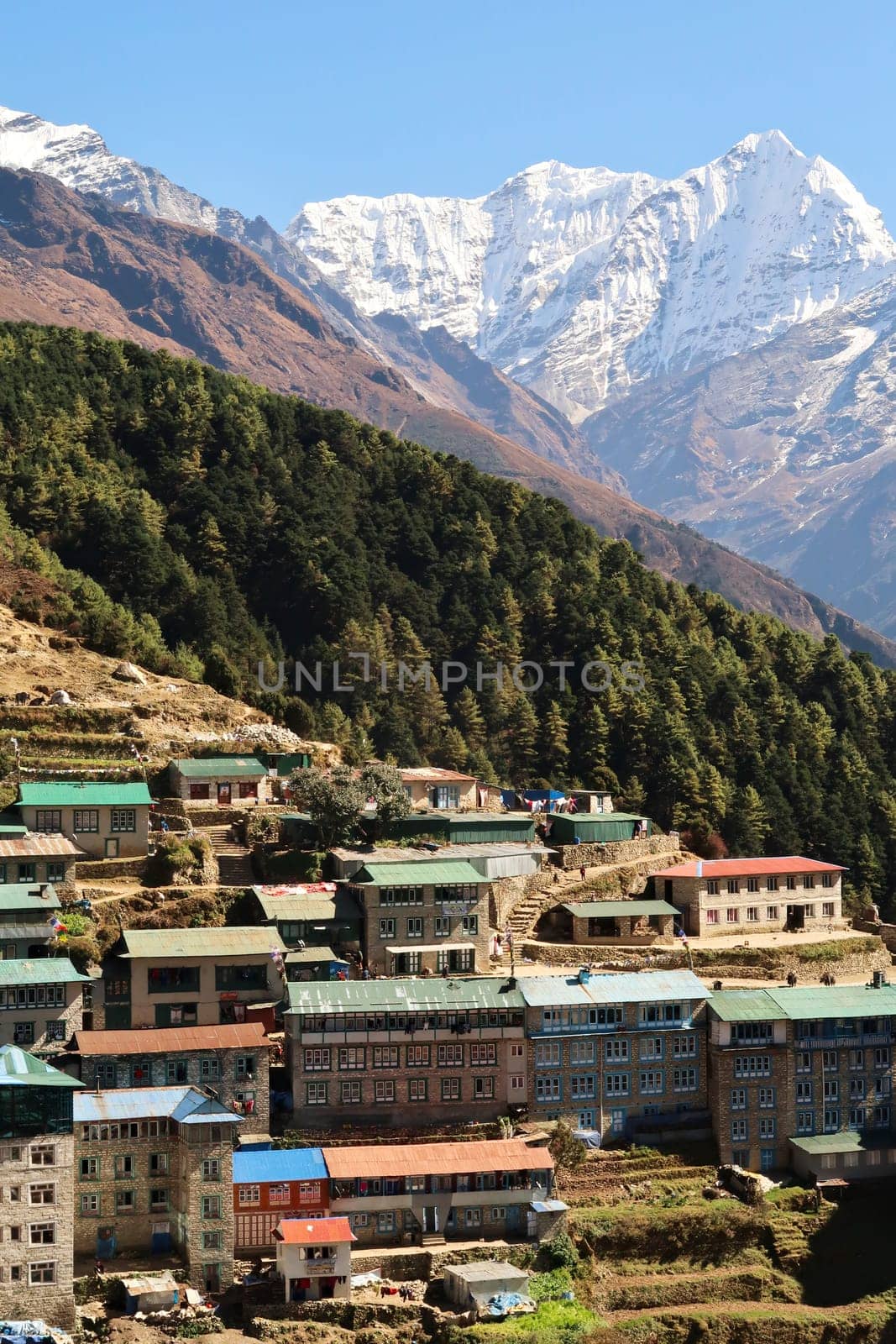 View onto a colorful neighborhood of Namche Bazaar, Bazar with Mount Kusum Kanguru, Kangguru rising in the background, Mount Everest Base Camp Trek, EBC, Nepal 2022