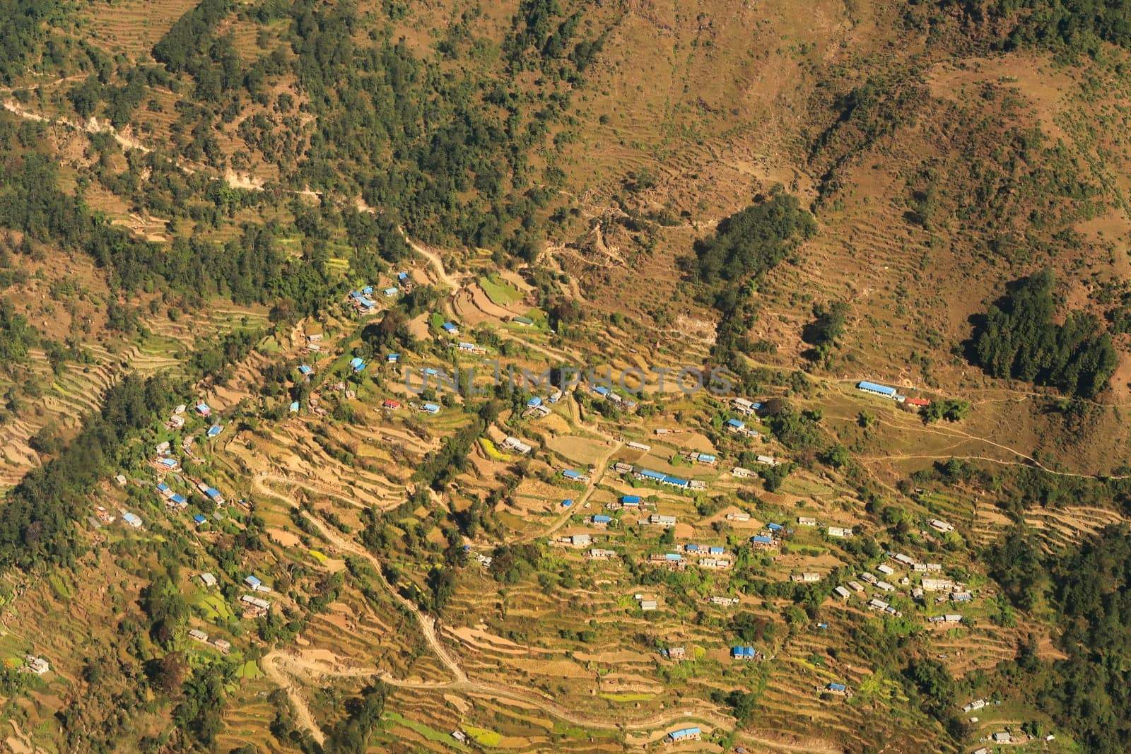 View out of the window on the flight from Lukla back to Kathmandu onto a remote mountain village, traditional houses in between rice terraces, Mount Everest Base Camp Trek, EBc, Nepal 2022