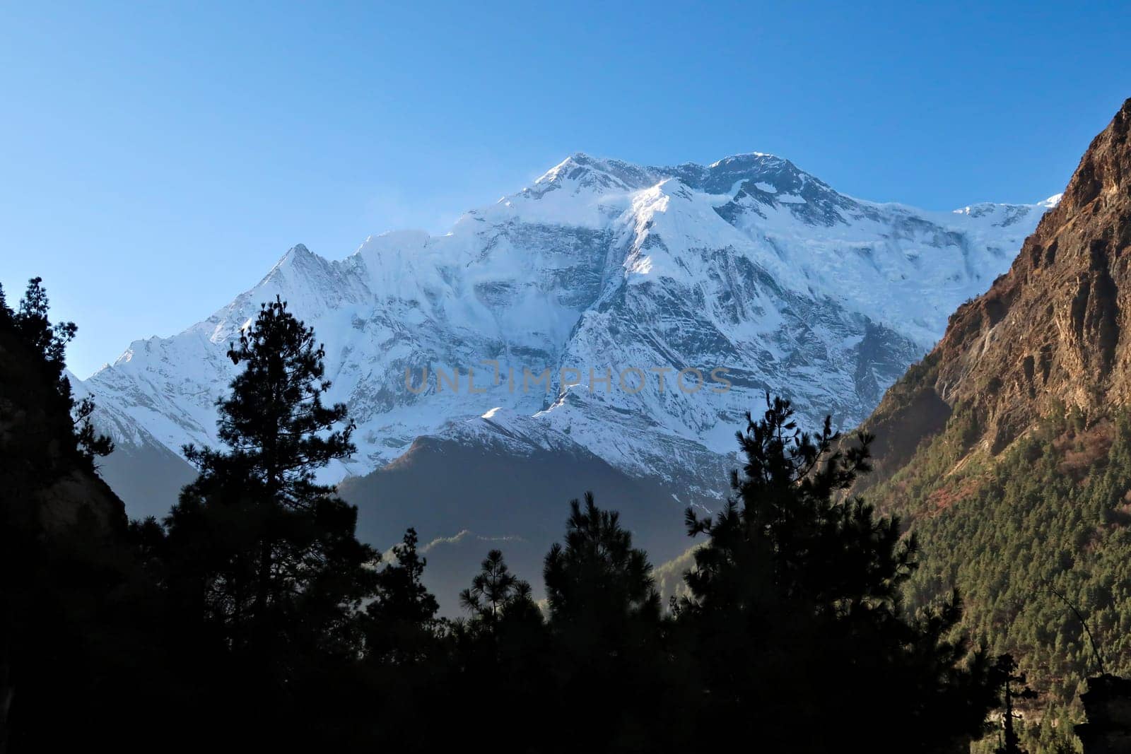 View from the trail from Upper Pisang up to Ghyaru onto the snow capped, covered peak of Mount Annapurna II, Annapurna Circuit Trek, Nepal 2022