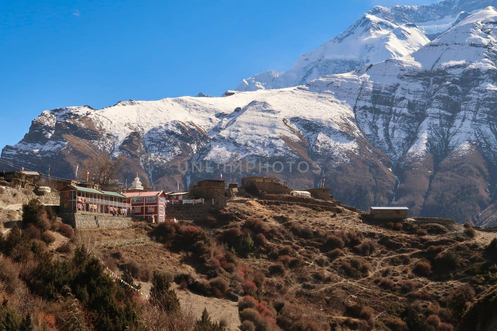 Looking back up to the traditional mountain village of Ngawal in front of the snow capped peak of Annapurna II, Annapurna Circuit Trek, Nepal 2022